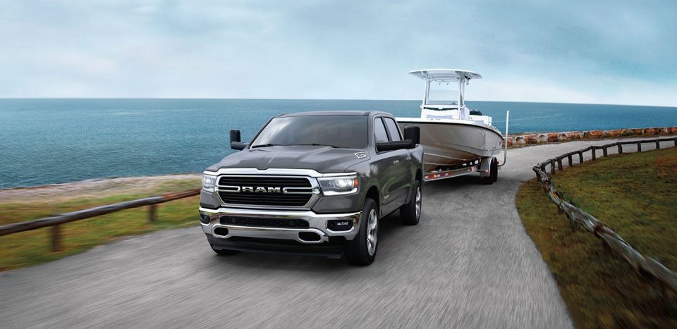 2020 RAM 1500 towing a boat on a coastline road