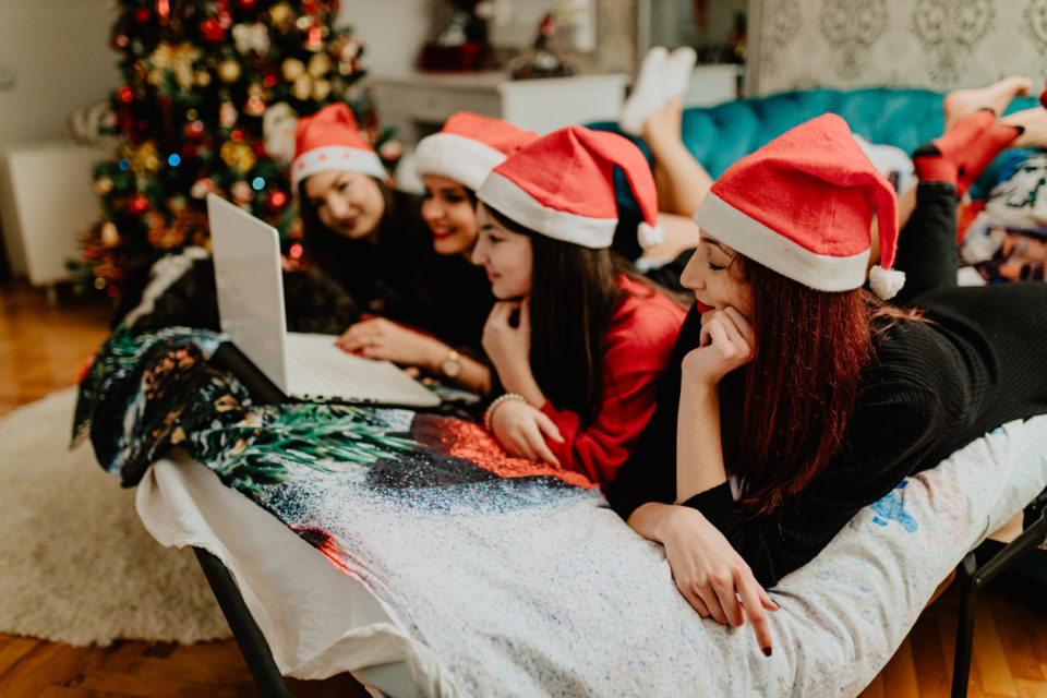 Family wearing Santa hats using laptop during Christmas holidays