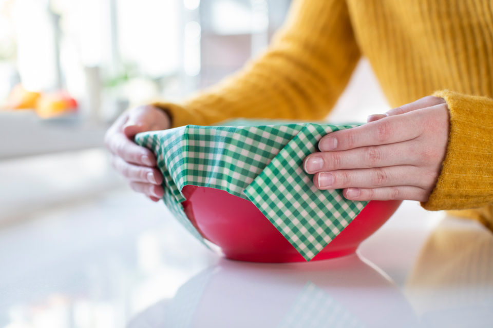 Woman wrapping up leftover food in eco-friendly beeswax wraps
