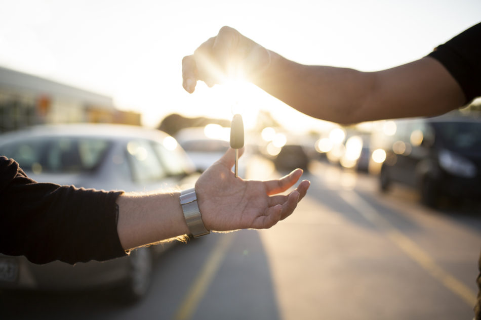 Salesperson passing over keys to the new owner