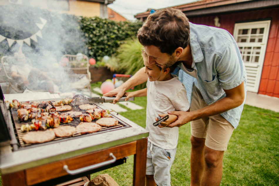 Father and son grilling meat together.