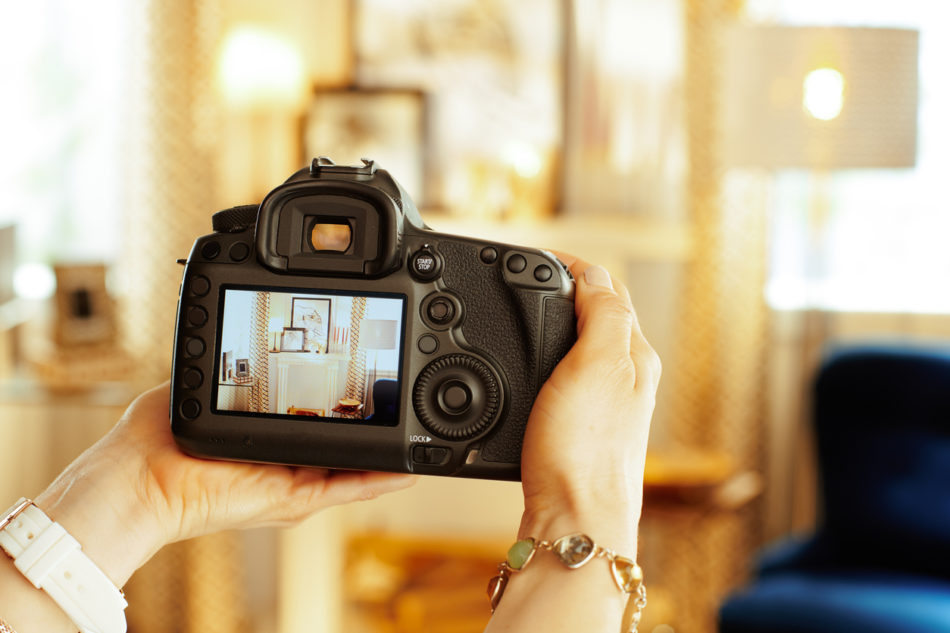 Photographer capturing a living room with a DSLR camera