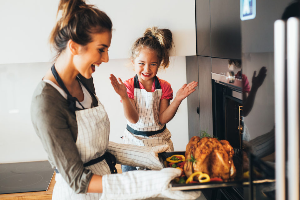 Mother taking the dinner out of the oven