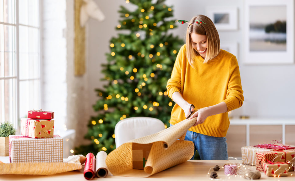happy woman gets ready for christmas and wrapping a gift