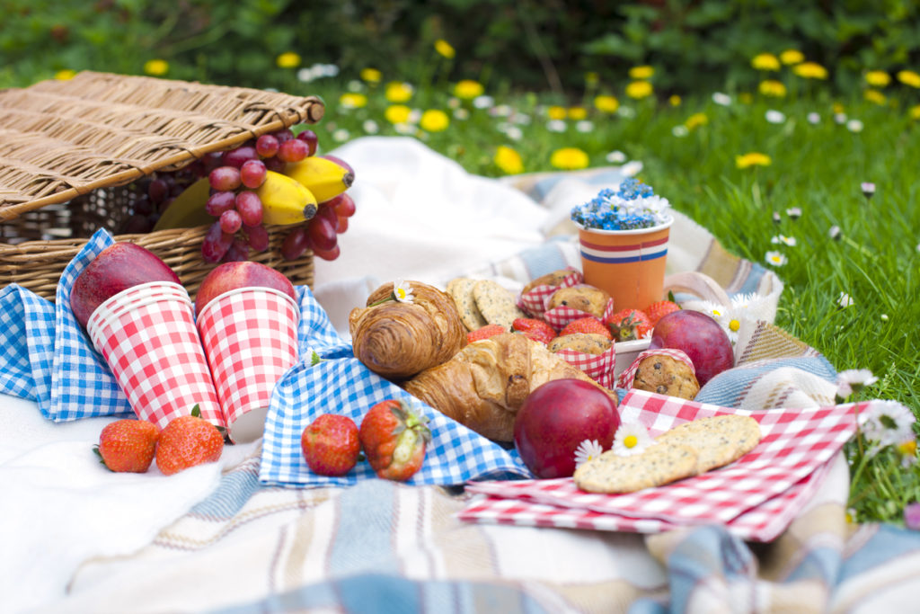 Picnic basket on a blanket with fruit
